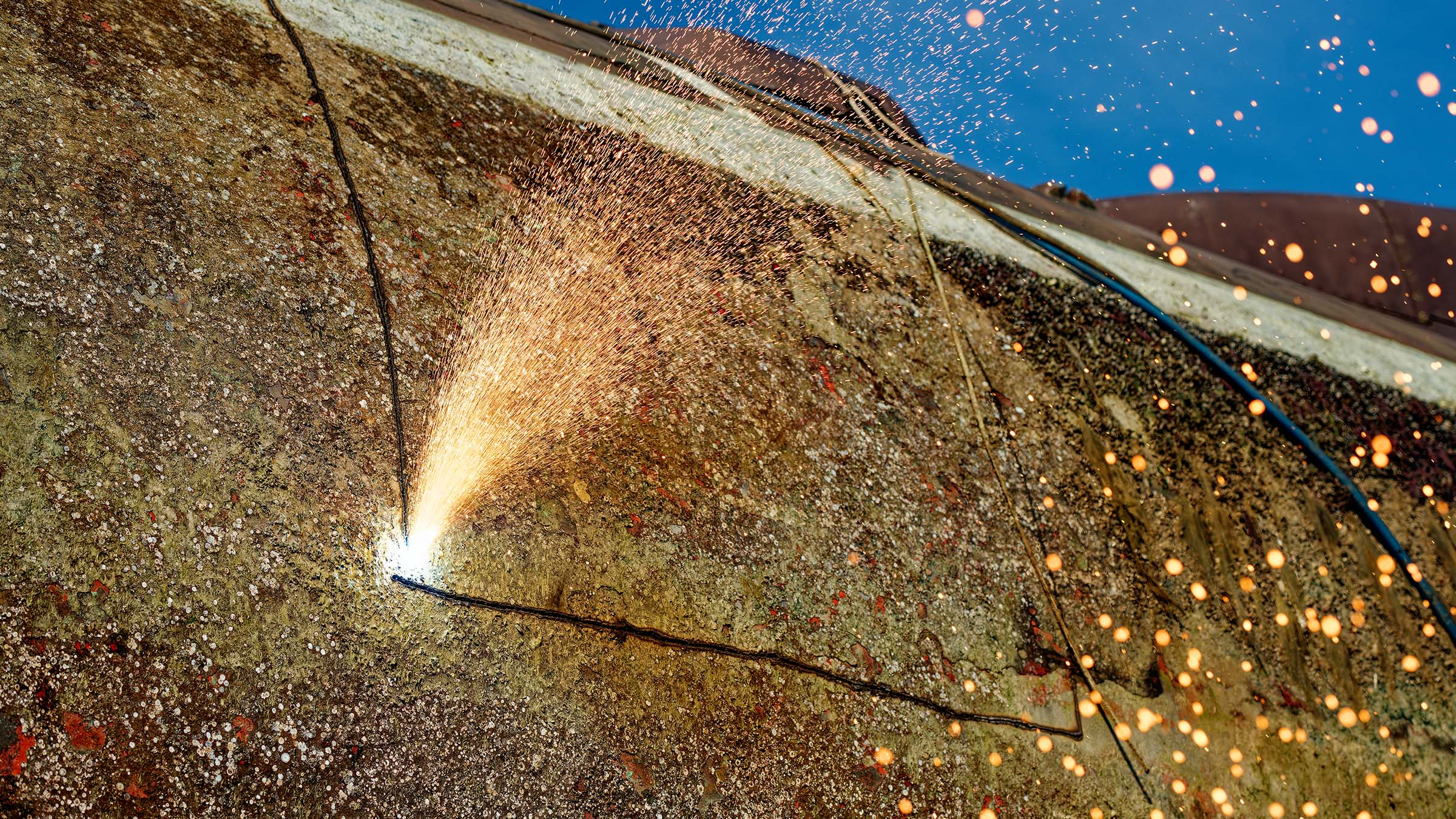 German submarine steel is extracted from a decommissioned submarine, visible sparks during cutting.